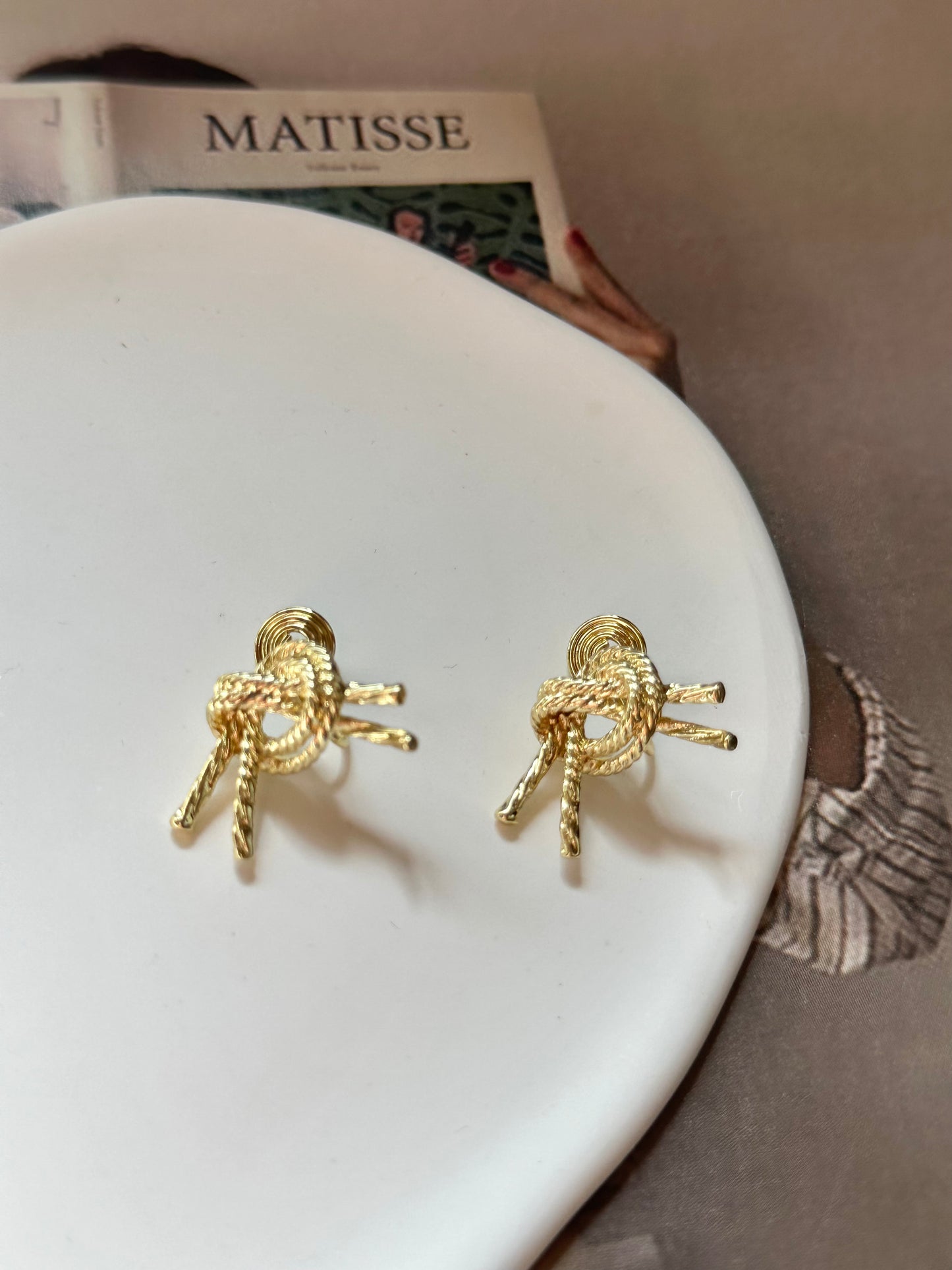 Golden Metal Knot Clip On Earrings. gold-tone clip-on earrings for women.